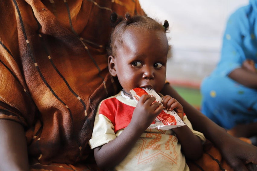 A child suffering from malnutrition eats ready-to-use therapeutic food at a UNICEF-supported Primary Health Clinic in North Darfur, Sudan.