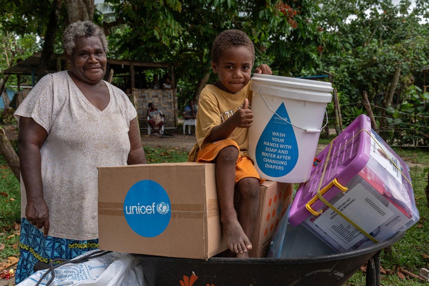 A grandmother and her four-year-old grandson collect an emergency kit from UNICEF after an earthquake struck in Vanuatu.