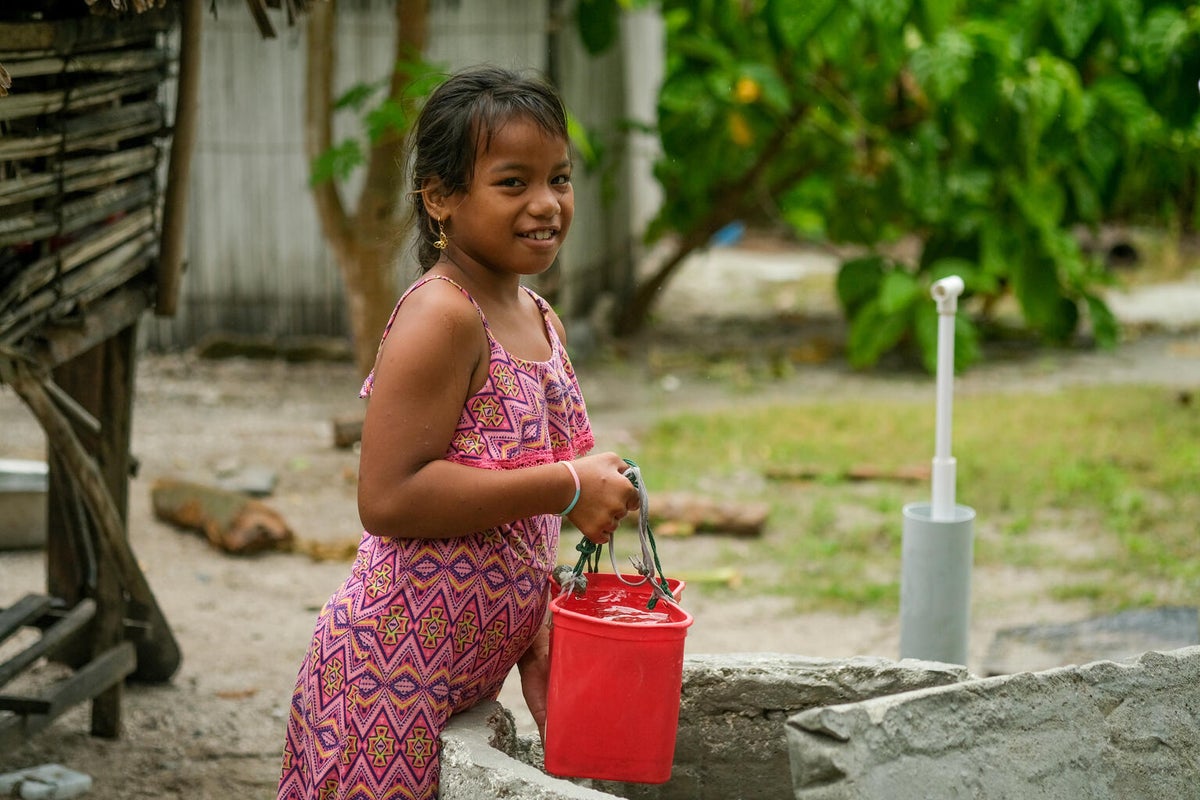 A young girl from the Pacific Island nation, Kiribati, collecting clean water.