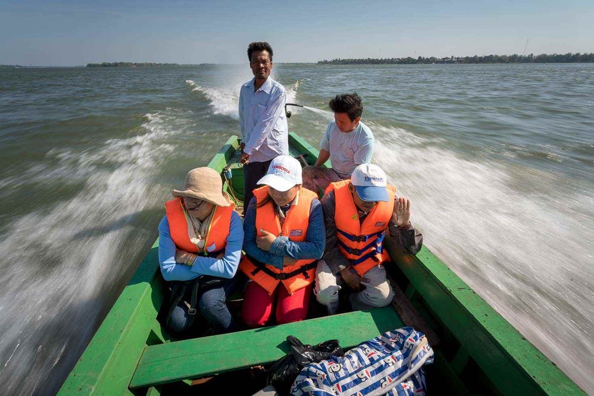 Health workers deliver vaccines to children on a speedboat, crossing Mekong River in Cambodia. 