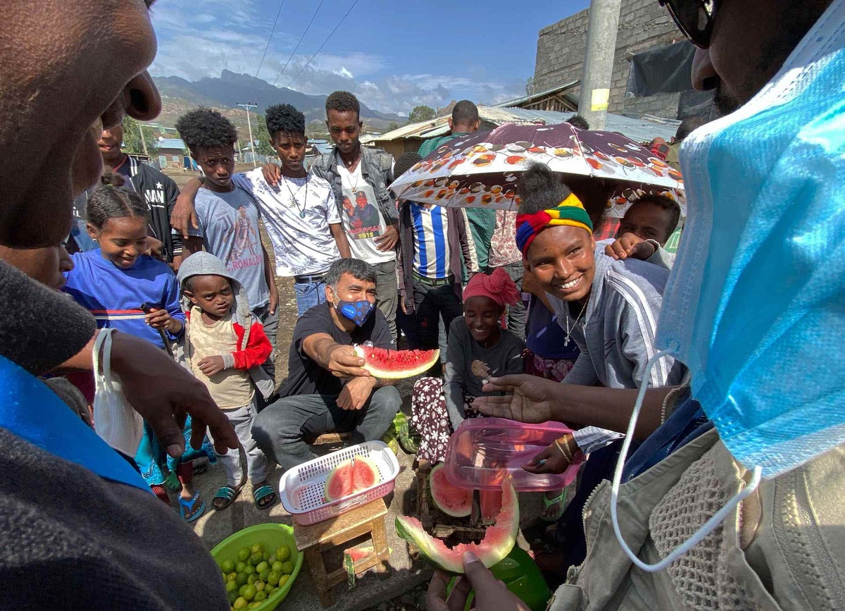UNICEF Ethiopia health Specialist Dr. Muhammad Is-haq Khan takes a break from his duties to help a vendor (right) by selling fresh watermelon in Tigray, Ethiopia