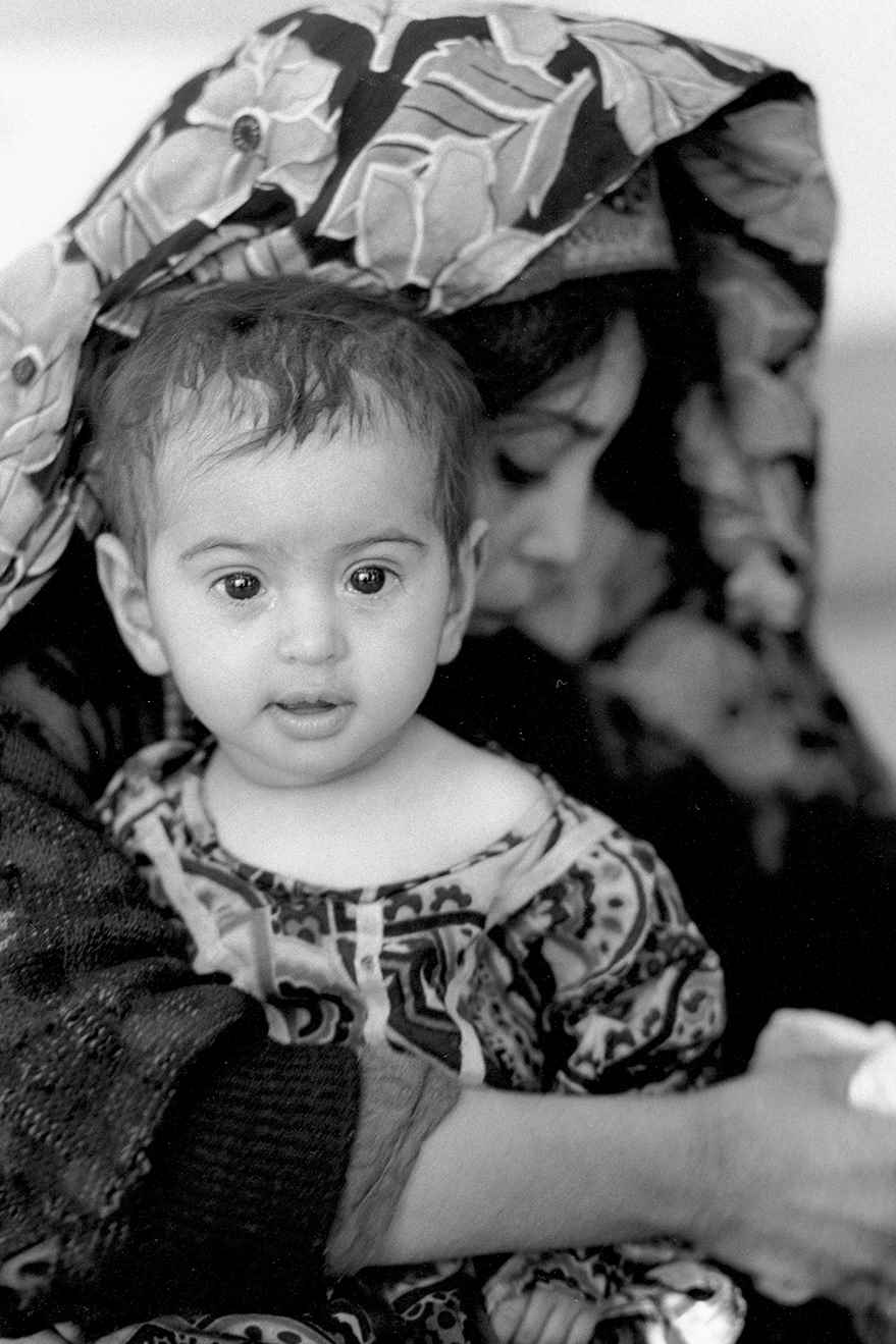 A little girl waits to be attended to at a therapeutic feeding centre for displaced persons in 2000. 
