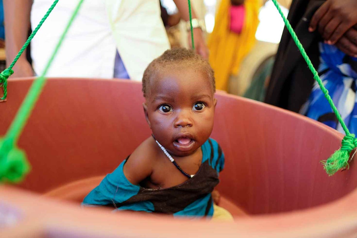 Child is weighed in a bucket