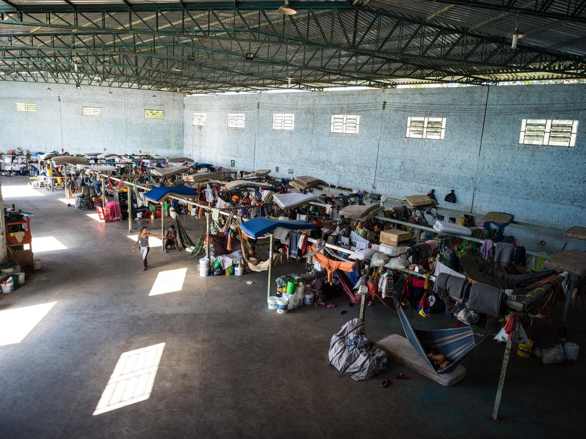 A shelter where there's mattresses and people with personal belongings.