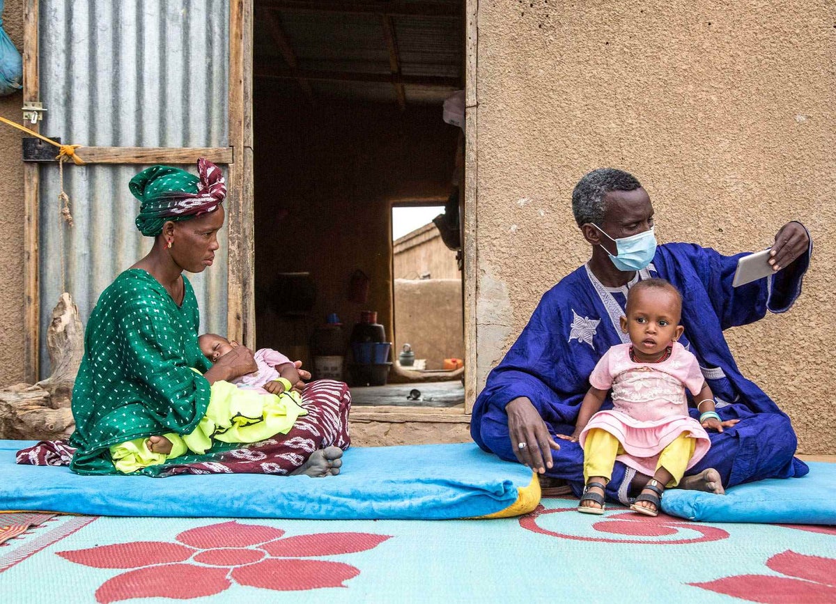 Mamadou, a UNICEF volunteer resource person in Djinja, Mauritania, chats with a local mother and checks on her children during a home visit