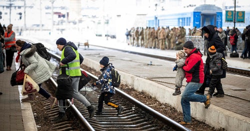 Ukrainian family running across train tracks as they fled the war in Ukraine.
