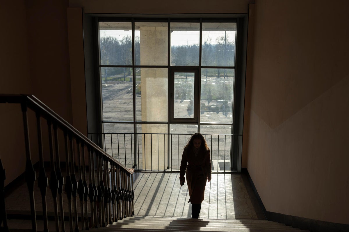 School student walks up steps inside a school building.