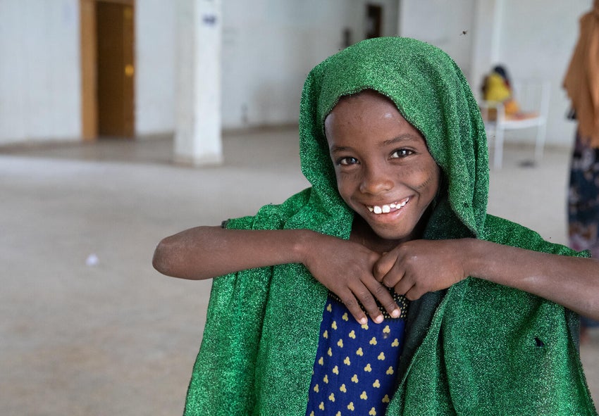 A young girl smiles to the camera