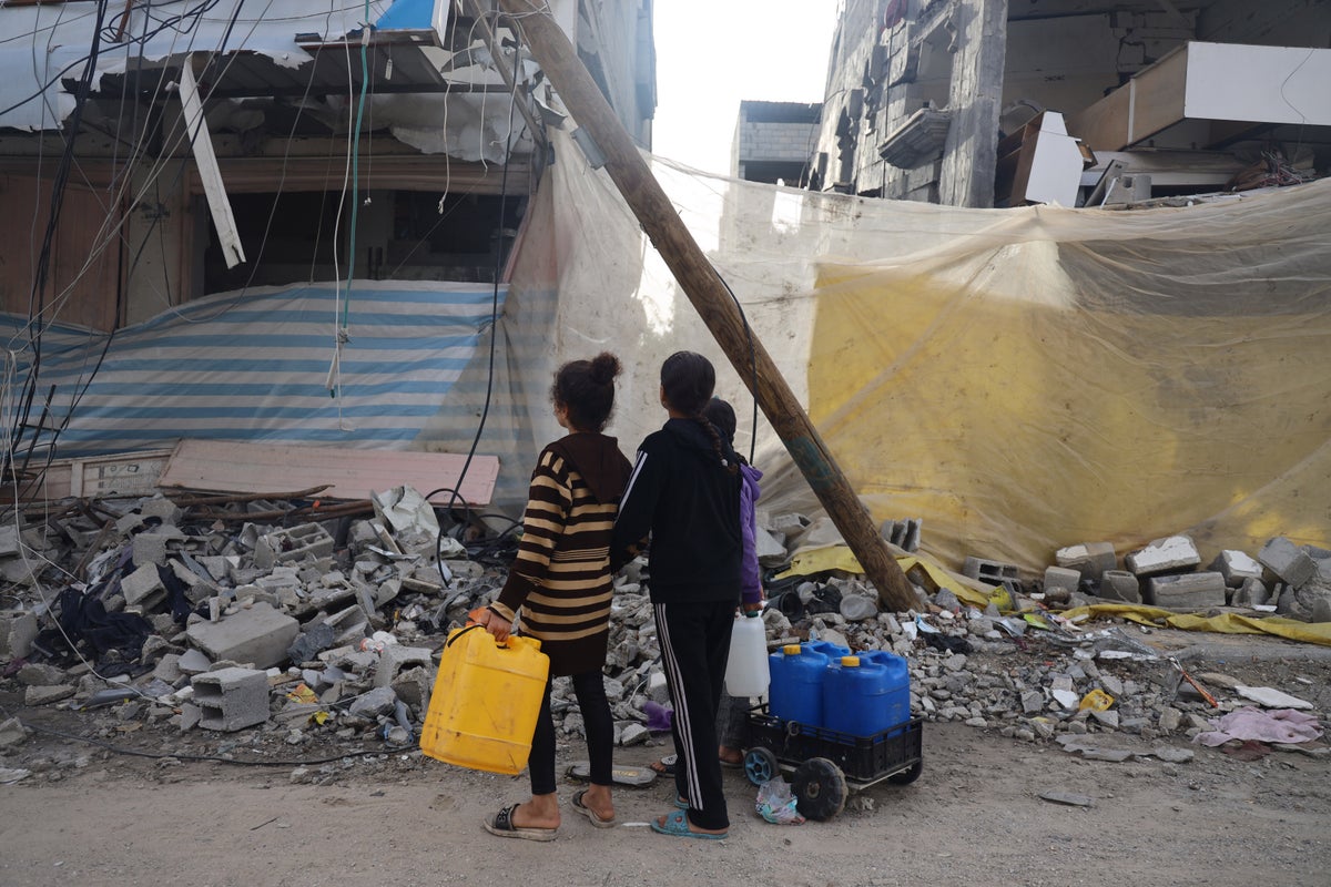 Two children collect water in Khan Younis city, south of the Gaza Strip, amid escalating hostilities. 
