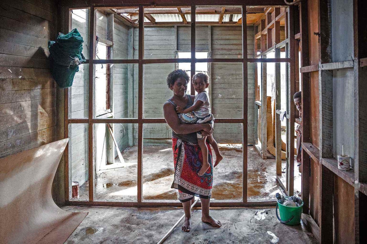 Kolora holds her daughter Semaima in what is left of their home after Cyclone Winston devastated Fiji.  