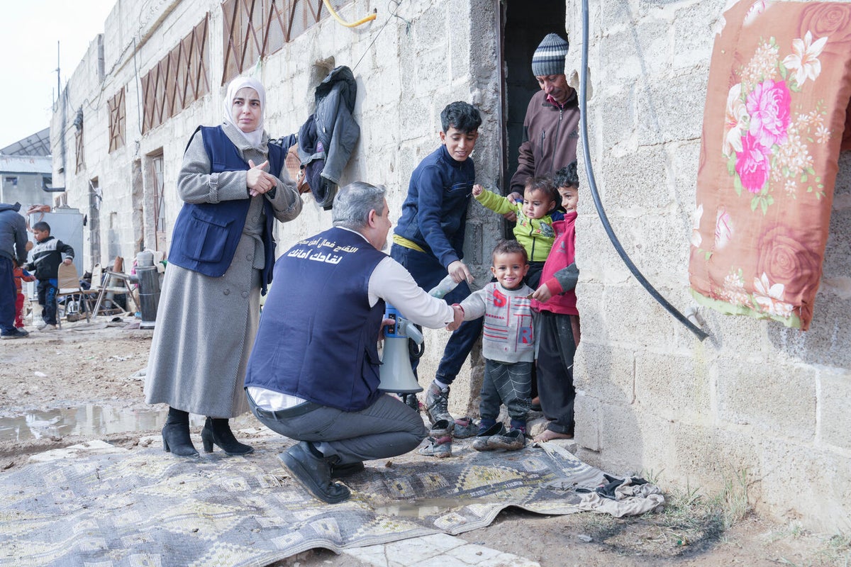 Othman, 3, greets community health worker Mohamed as a vaccination team arrives at his home during an immunisation campaign in Syria.