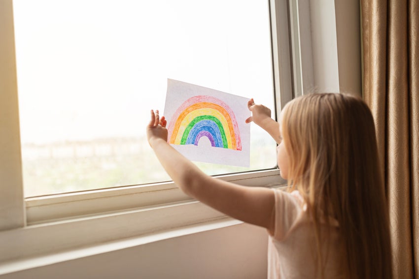 Girl staring out the window at the camera.