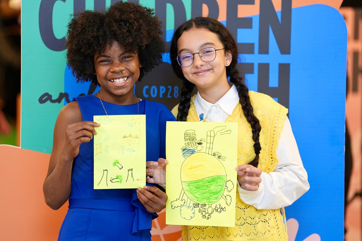 On 8 December 2023 at the UN Climate Change Conference (COP28) at Expo City Dubai in the United Arab Emirates, UNICEF Youth Advocates poses for a photo with their drawings.