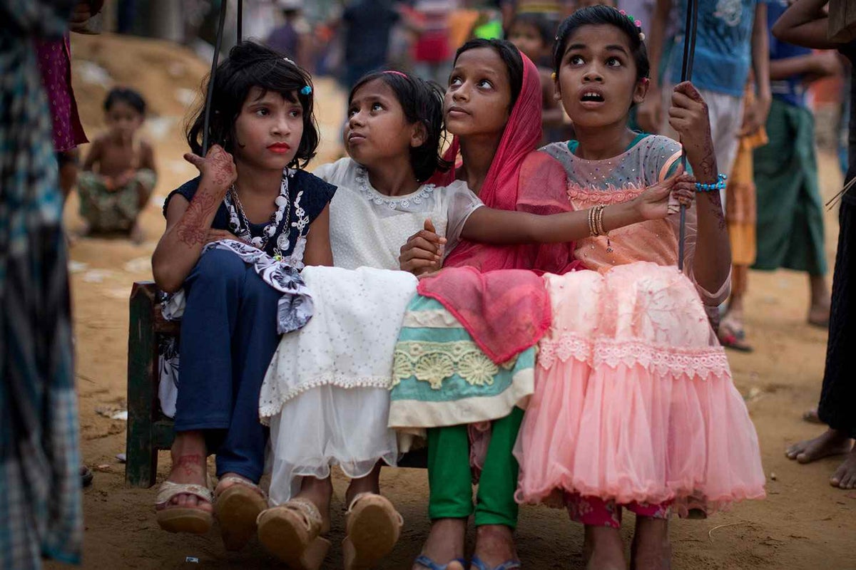 Girls play on a hand-made ferris wheel in the Rohingya camps, Bangladesh