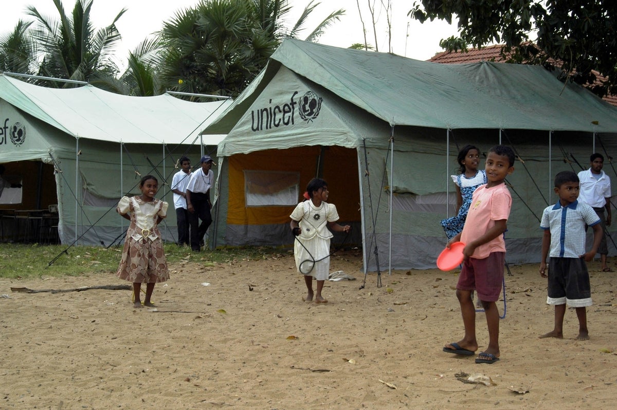 Children displaced by the 2004 Indian Ocean tsunami play in front of UNICEF tents in a relief camp in Sri Lanka.
