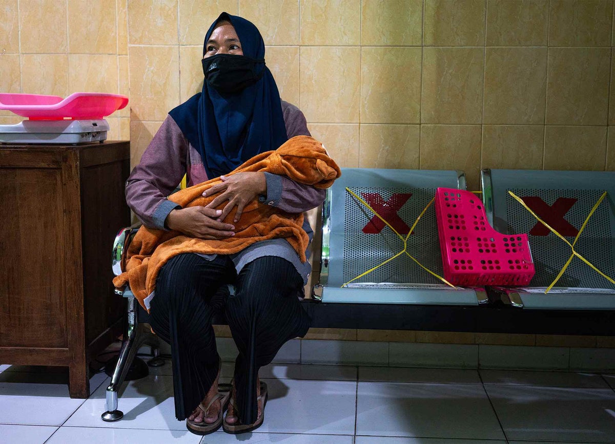 A mother waits for her child to be vaccinated