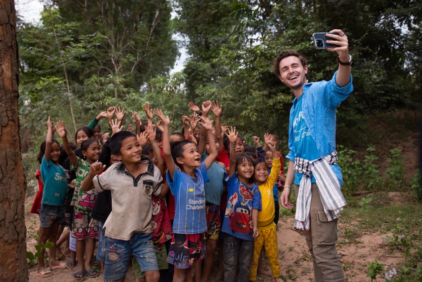 Callan McAuliffe poses with kids in Laos