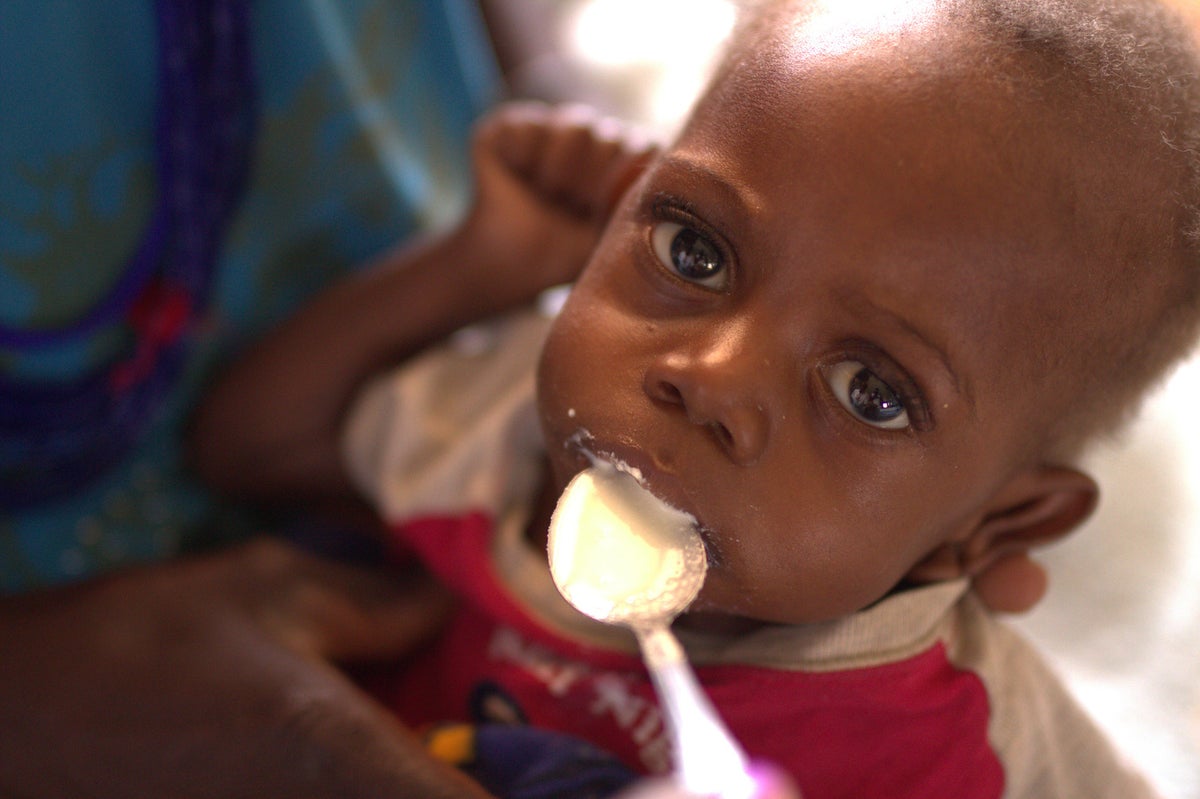 A baby is having a spoonful of food.