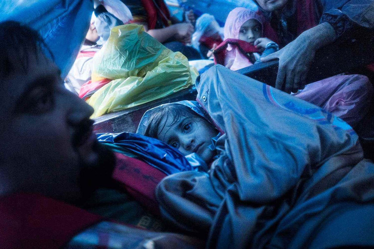 A young girl crowds with other asylum seekers under a tarp while making the three-day boat journey from Indonesia to Australia in 2013. 