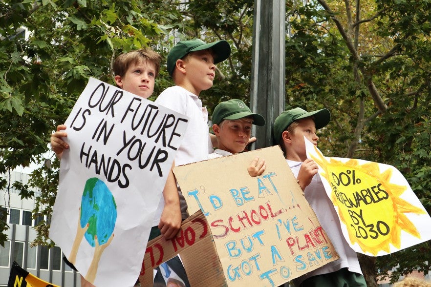 These boys held their signs on a ledge above the crowds on Friday.