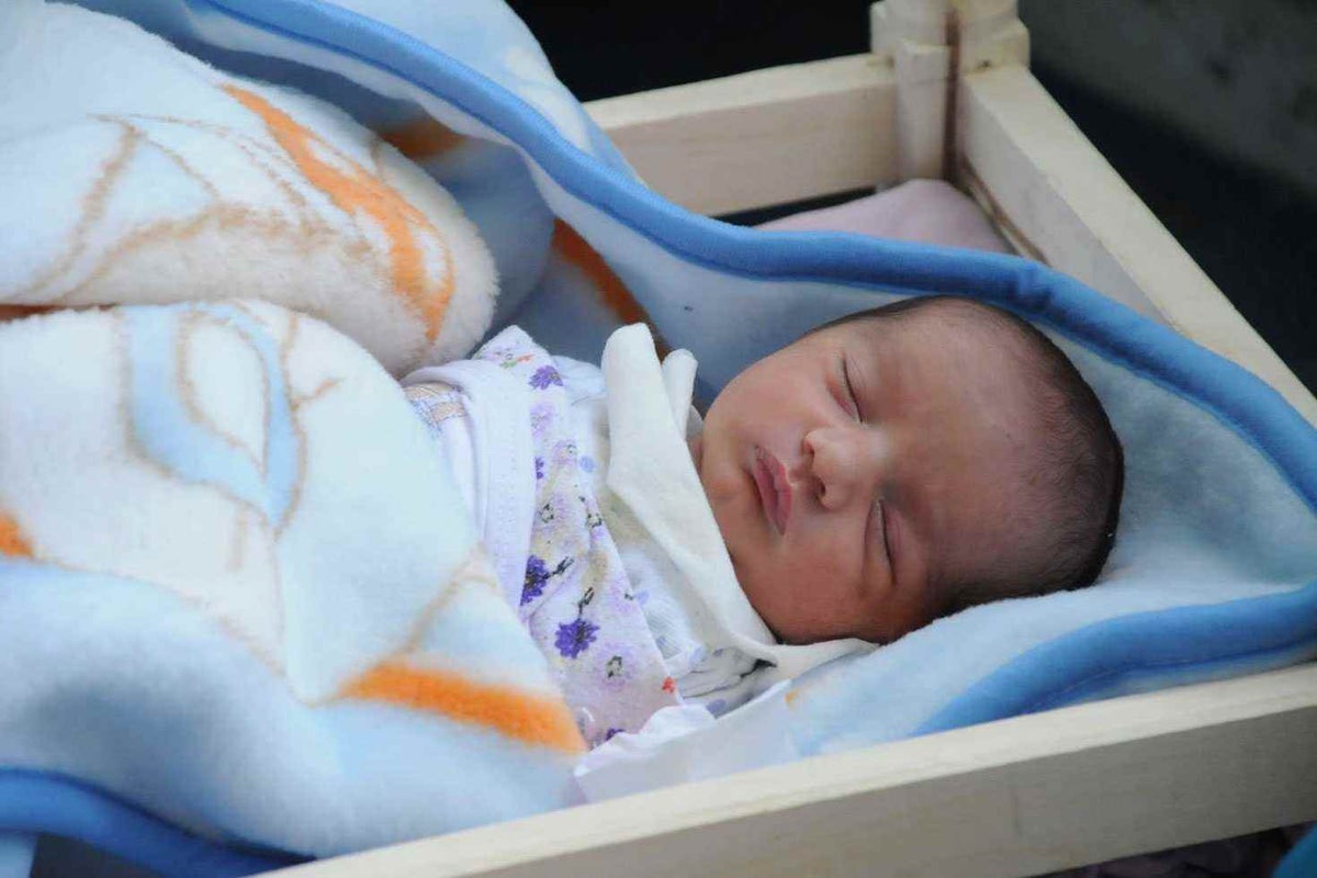 Three-day-old Yusuf sleeps in school gymnasium being used to shelter Syrian refugee families