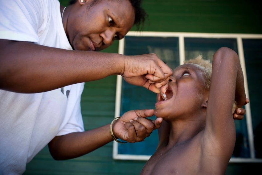Health care worker giving oral vaccine