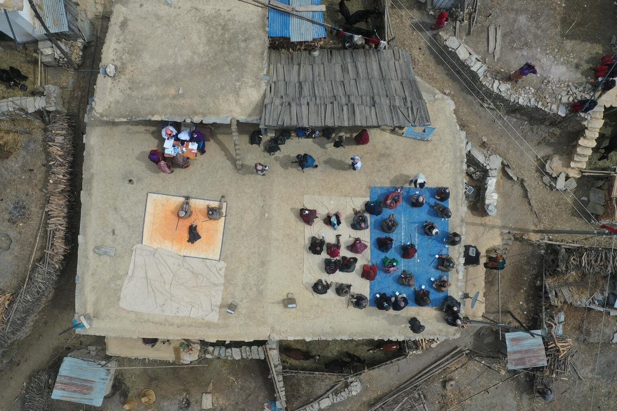 An aerial image of a group of people seating on the floor, waiting for their turn to get the shot.