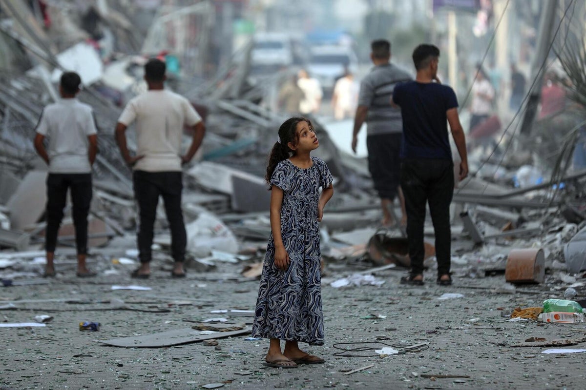 A seven-year-old girl stands out the front of destroyed homes at the Gaza Strip.  