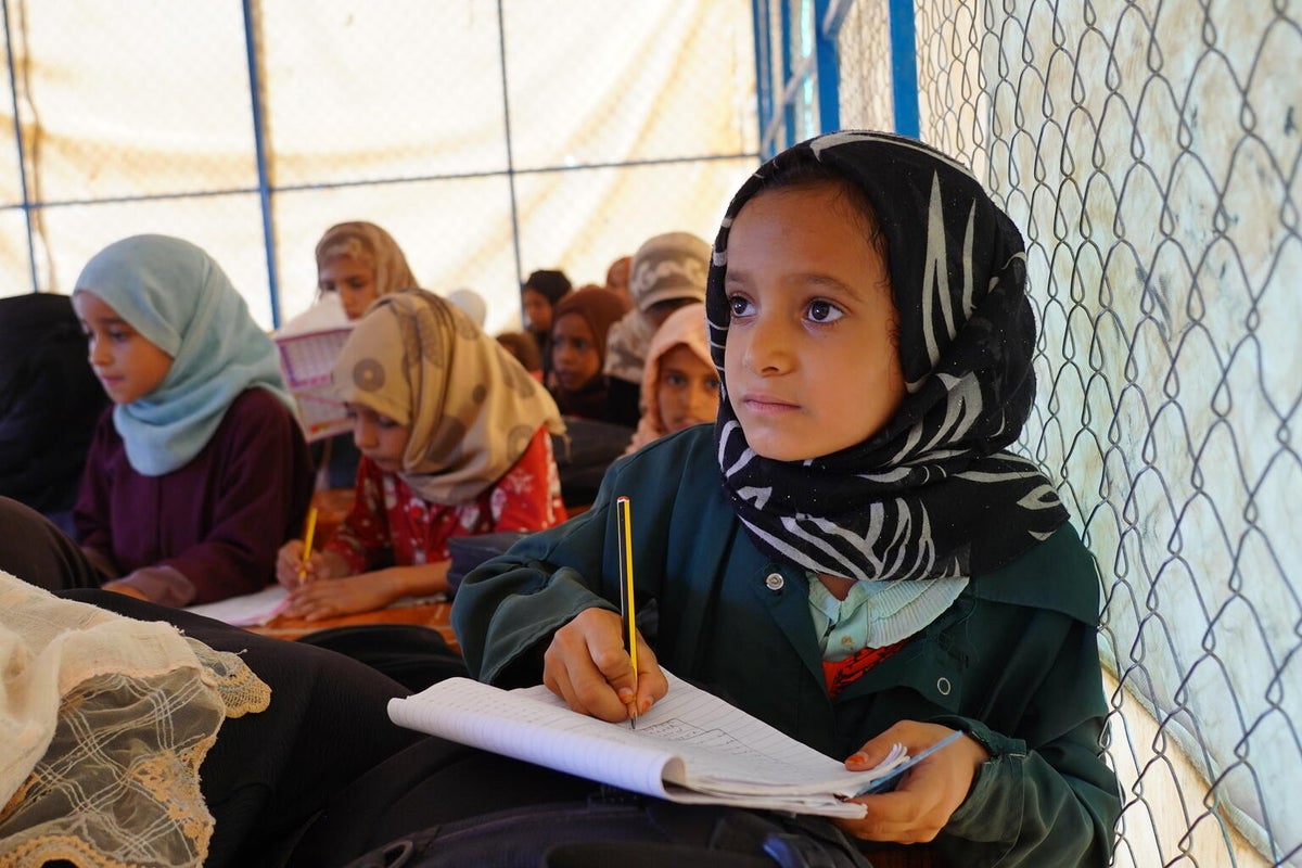 A young girl from Yemen is learning in a makeshift classroom in a camp for Internally Displaced People