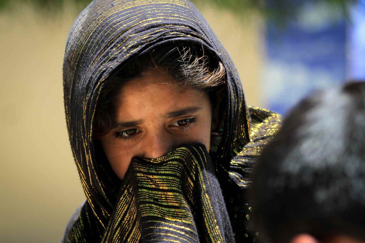 Girl covering her face with head scarf