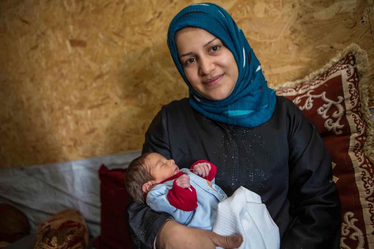 Gihan holds her newborn son Mohammed in the Domiz refugee camp in Northern Iraq in 2014. 