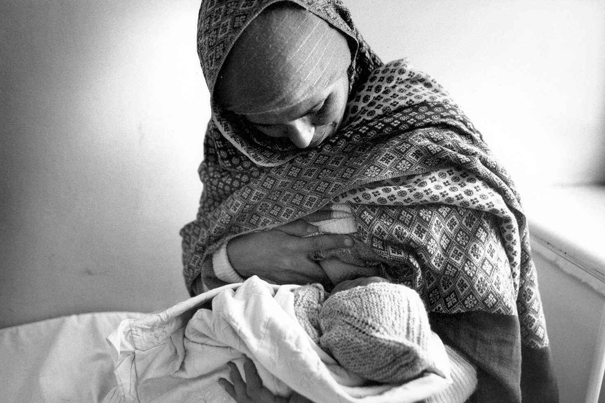 A woman breastfeeds her child at the UNICEF-sponsored basic services centre for women in Bagrami village, outside Kabul, in 1992.