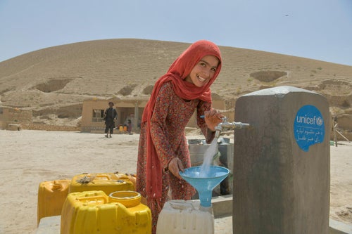 A girl collects water from a tap