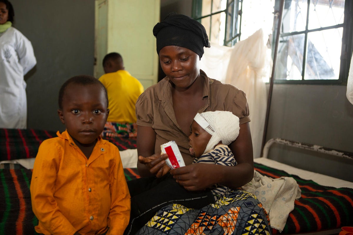 A mother of seven supports her child receiving treatment for severe acute malnutrition at a hospital in Burundi.