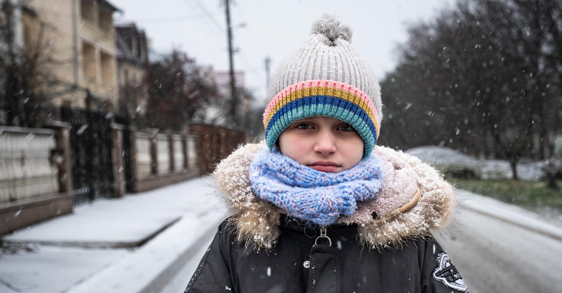 A young girl rugged up and standing on the snowy streets of Ukraine.