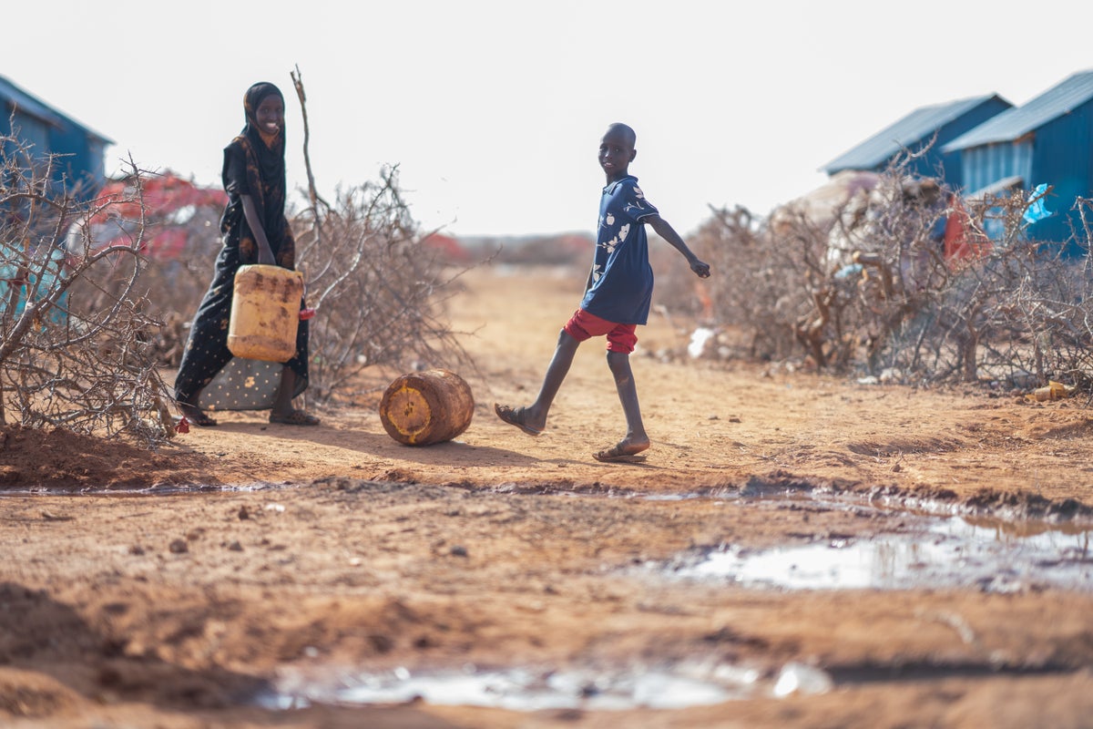 Children play with barrels for collecting water