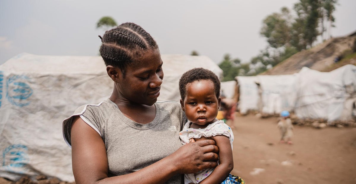 At a camp for internally displaced people in the DRC, Nehema holds her two-year-old daughter Queen, after visiting a UNICEF-supported mobile health clinic.