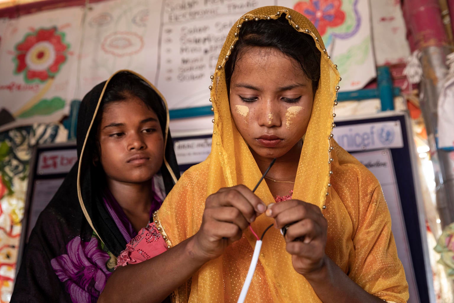 Nur (yellow scarf), 16, prepares her tools while attending a workshop on installing and repairing solar panels that are ubiquitous in Kutupalong-Balukhali mega-camp, Cox's Bazar, Bangladesh