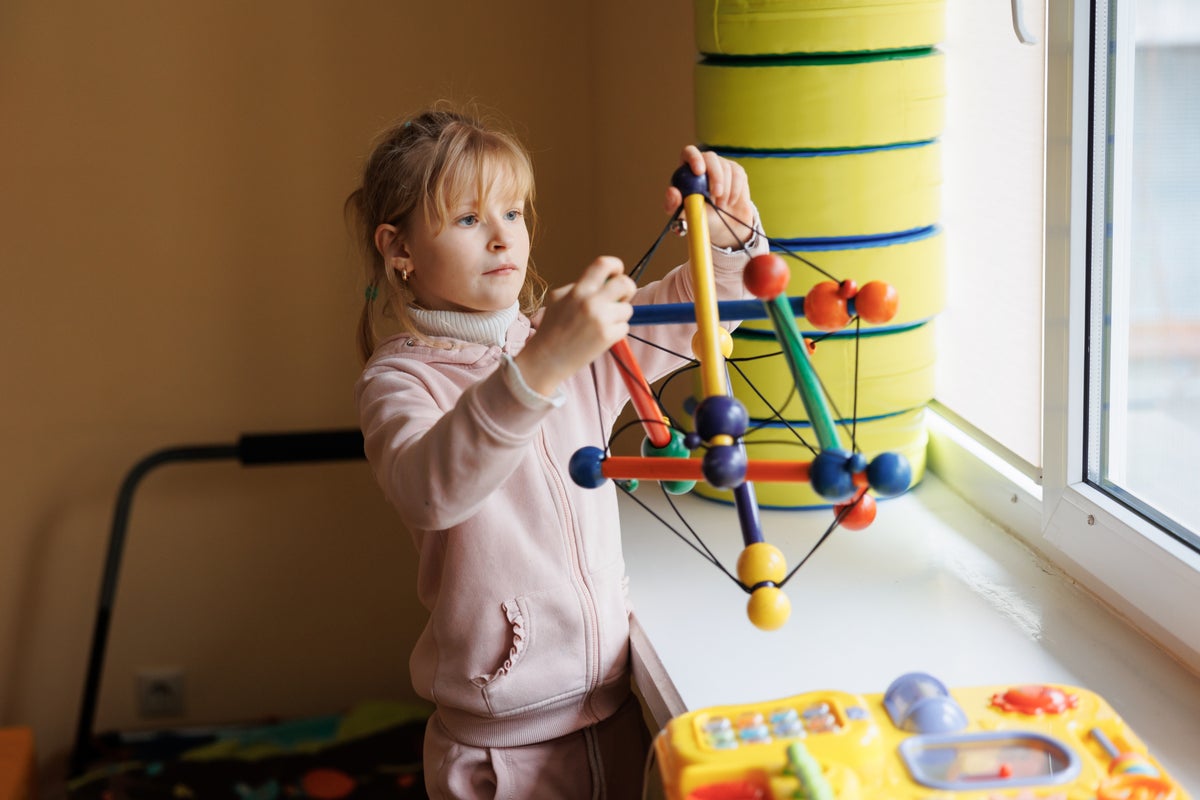 A young girl holding a learning toy.