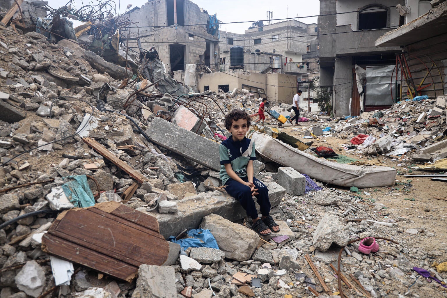 A young boy sits in the rubble in Gaza. 