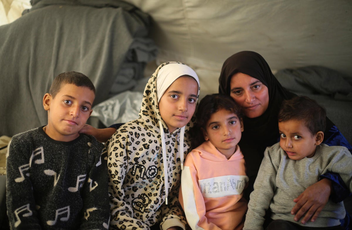 A woman with her children inside a tent.