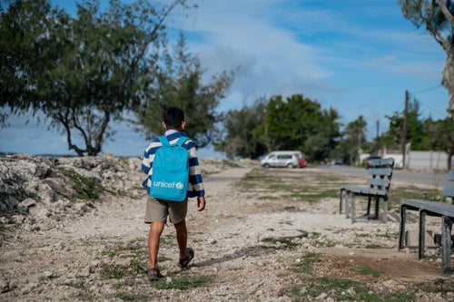 Young Tongan boy walking with A UNICEF backpack