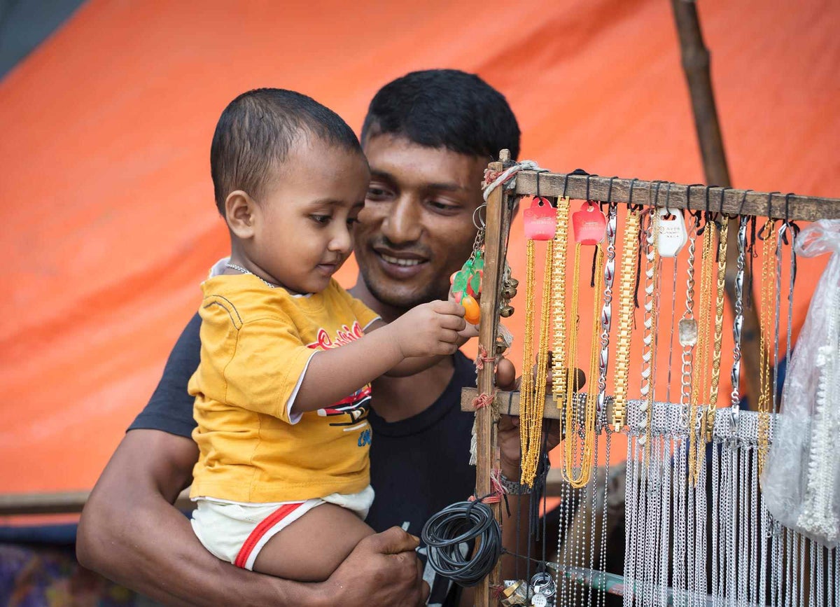 Zakir smiles as he watches joy on his son's face. 