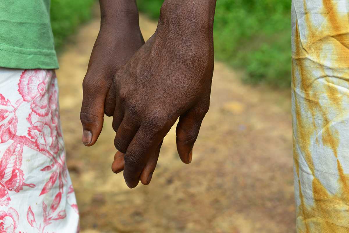 Musu Koroma, right, holds her son Sanfa’s hand. 
