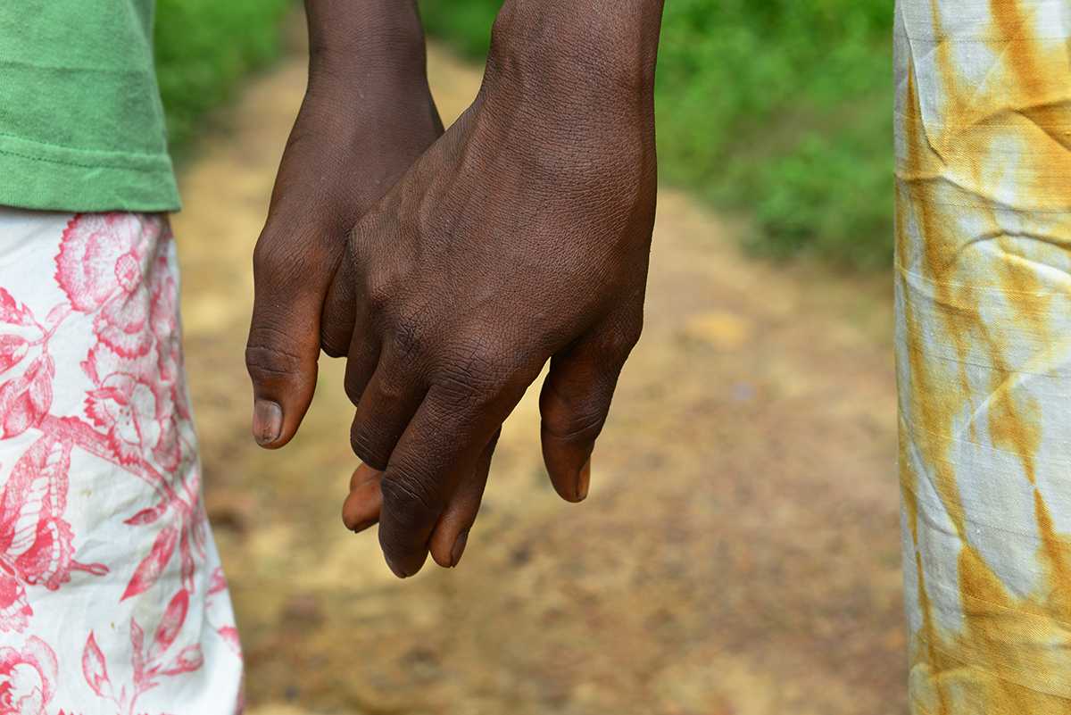 Musu Koroma, right, holds her son Sanfa’s hand.