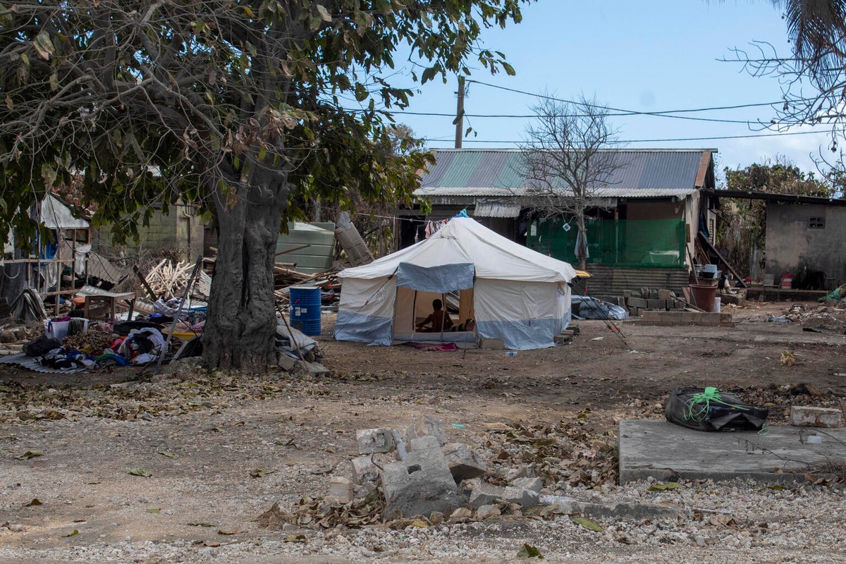 An emergency tent in front of a house.