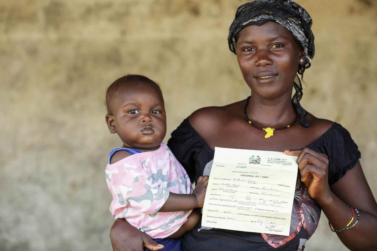 Kadiatu Koromo holds her son and his birth certificate in Bombali, Sierra Leone in 2013. 