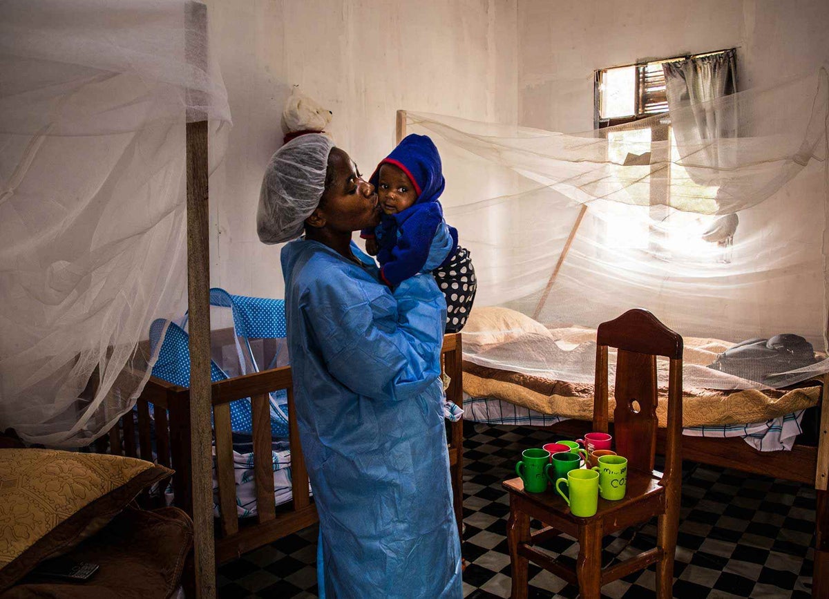 Ruth, a caregiver at the Ebola Treatment Centre of Butembo, kisses seven-month-old Christ-Vie, whose mother died of the illness just days earlier