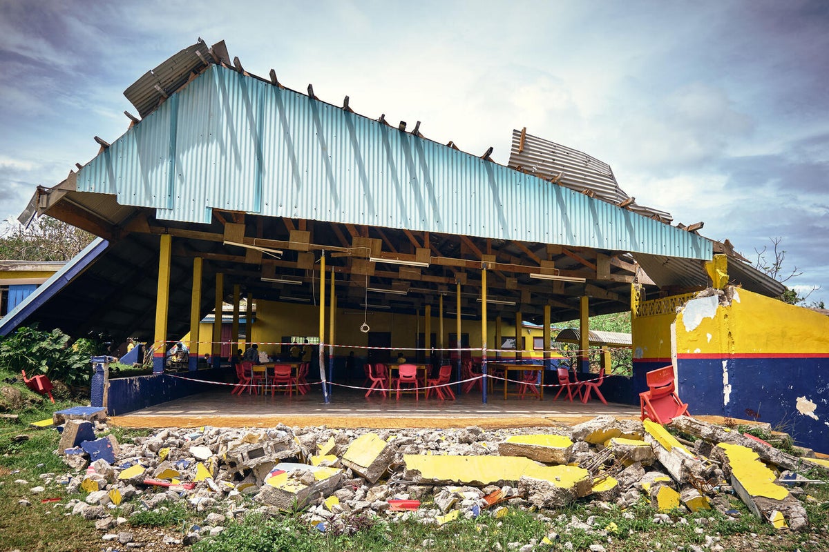 A destroyed building, surrounding by rubble. 