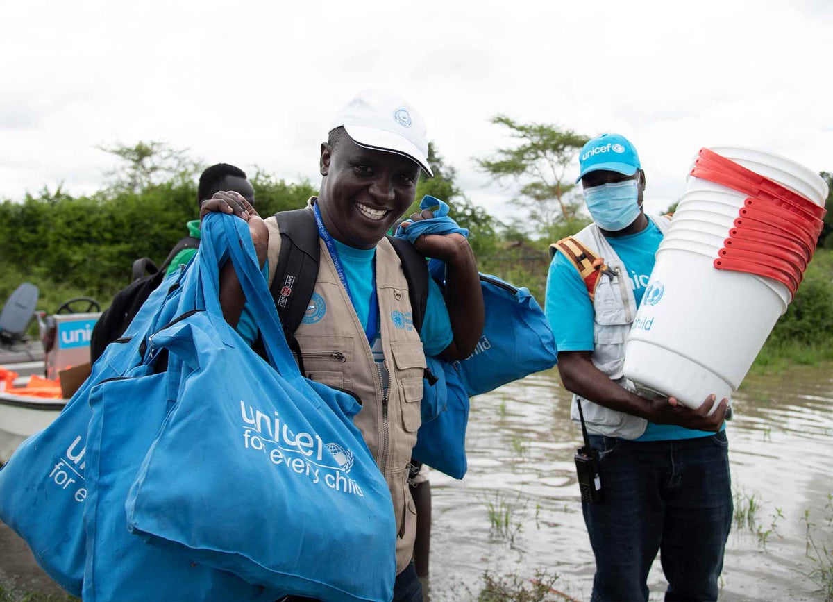 UNICEF emergency specialist Joseph Adiomo is offloading buckets from the boat in flooded Verteth. The buckets will be used for water purification